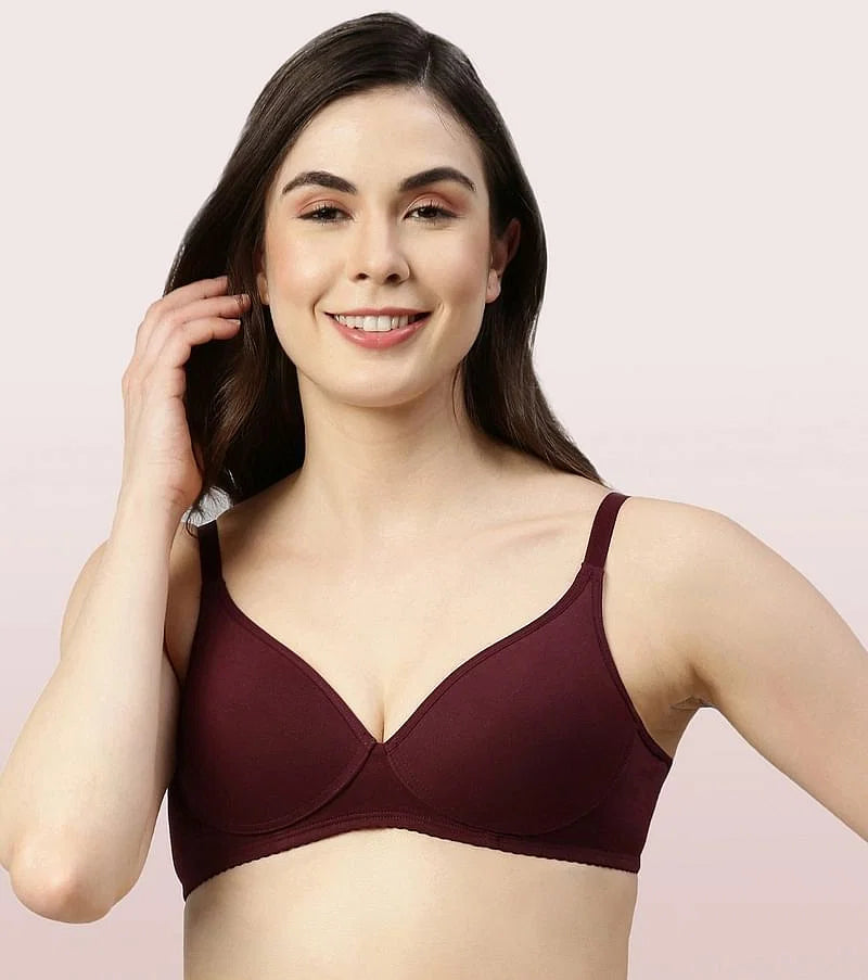 Woman wearing a wine bra against a light pink background